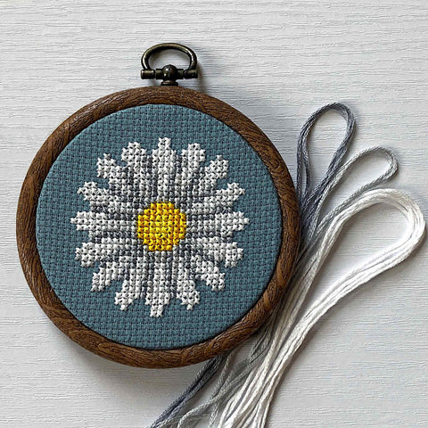 Daisy cross stitch on blue zweigart fabric with DMC threads