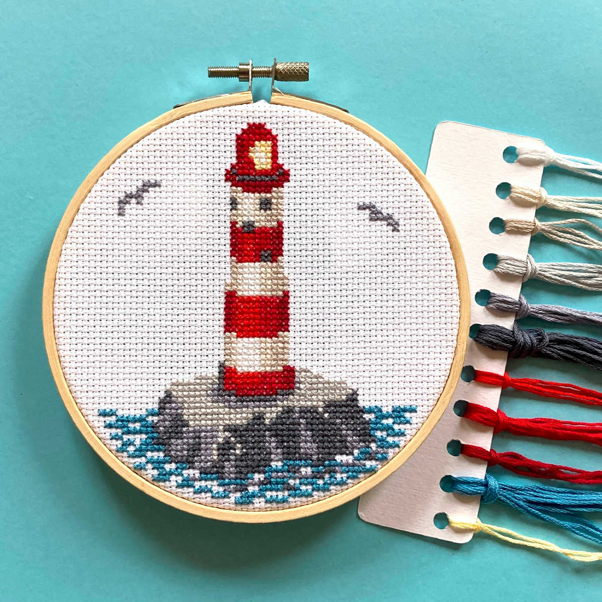 Red and white striped lighthouse at sea with seagulls cross stitch pictured in a 5 inch hoop with DMC threads