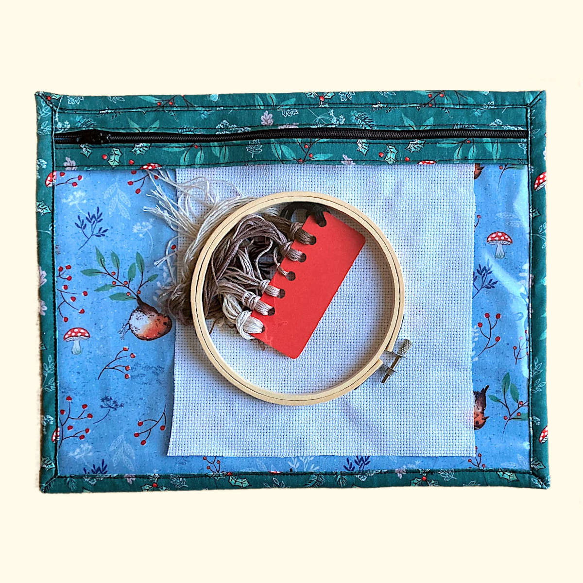 Poject pouch example use with embroidery threads and hoop inside seen through vinyl front