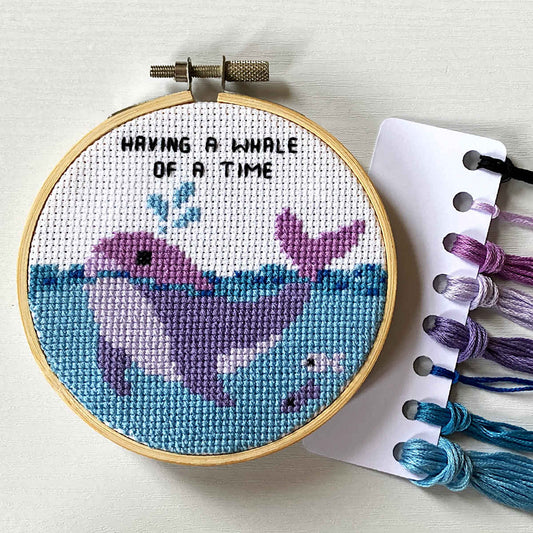 Purple whale cross stitch with 'having a whale of a time' caption in backstitch