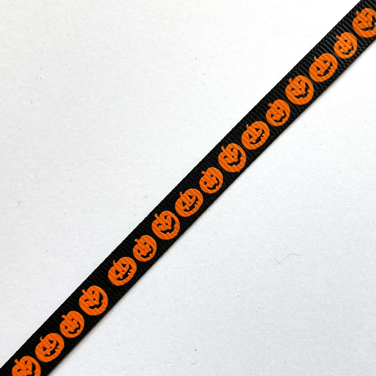 Black ribbon with orange jack o'lantern print, 9mm wide